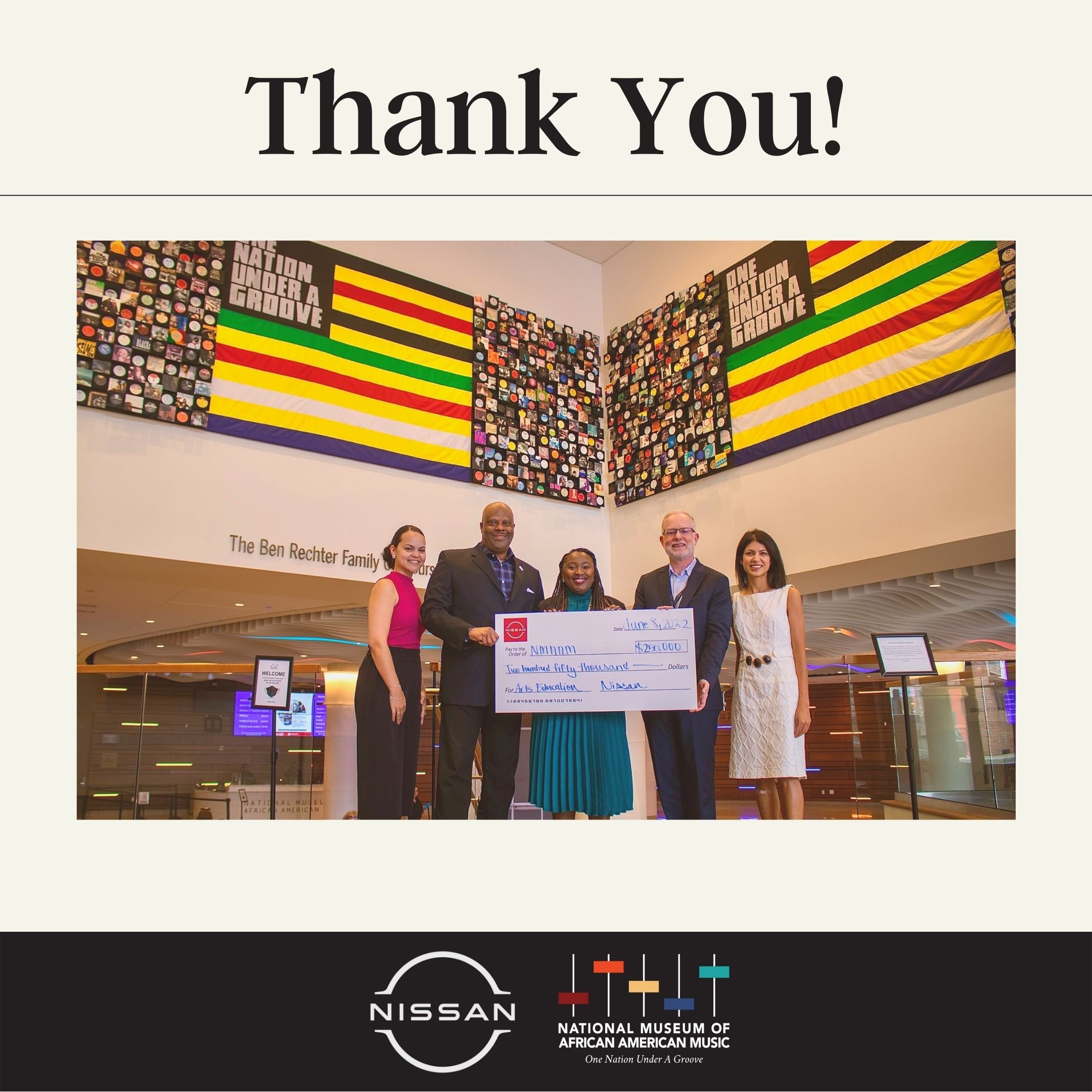 Photo of NMAAM leadership holding a giant novelty check in NMAAM Lobby