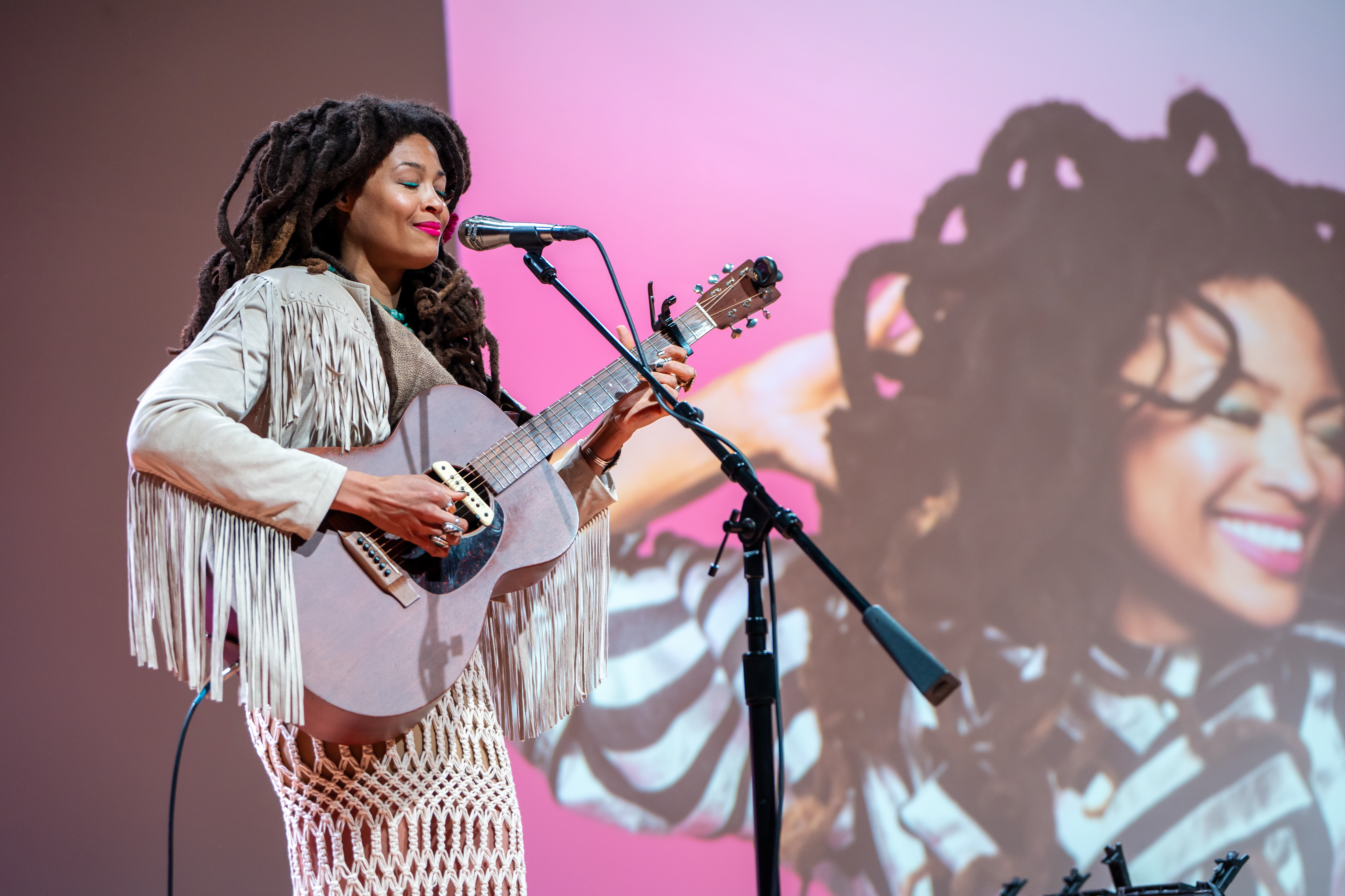 artist playing guitar on stage