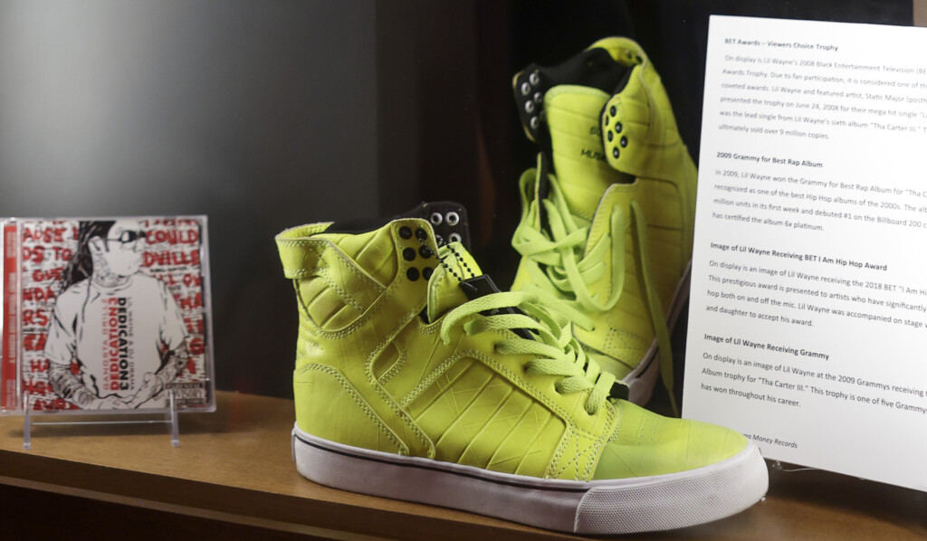 close up of exhibition artifacts in glass case: shoes, magazine, clothing, cd