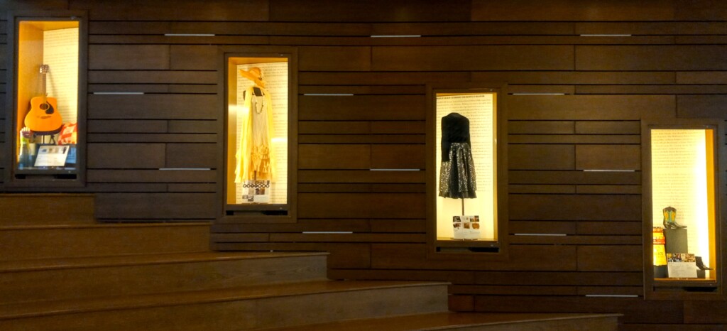 4 glass exhibitions cases featuring clothing and artifacts