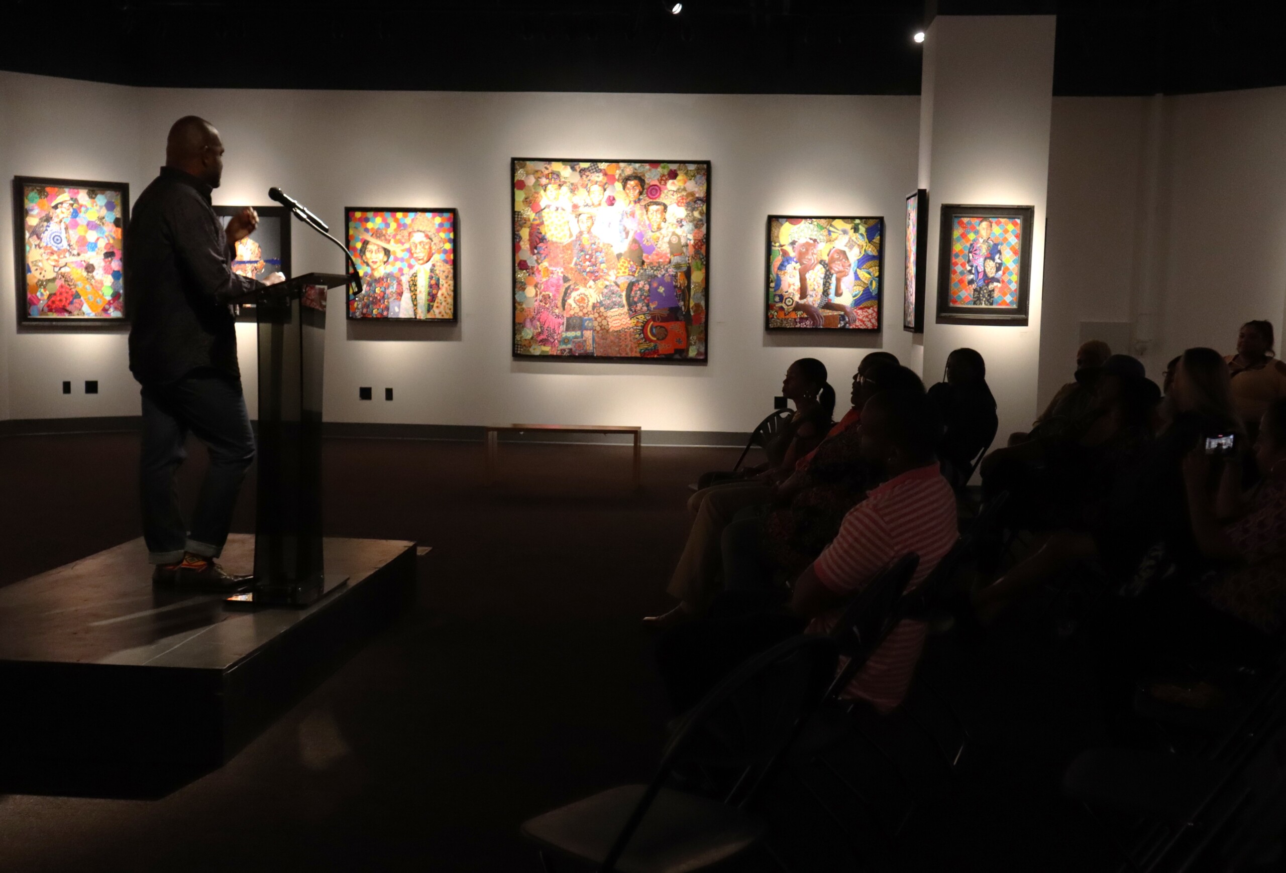 Artist speaking in front of crowd in Feature Gallery