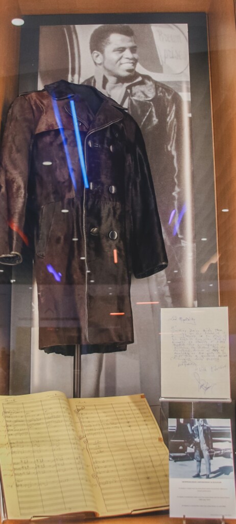 glass exhibition case featuring jacket worn by James Brown and artifacts