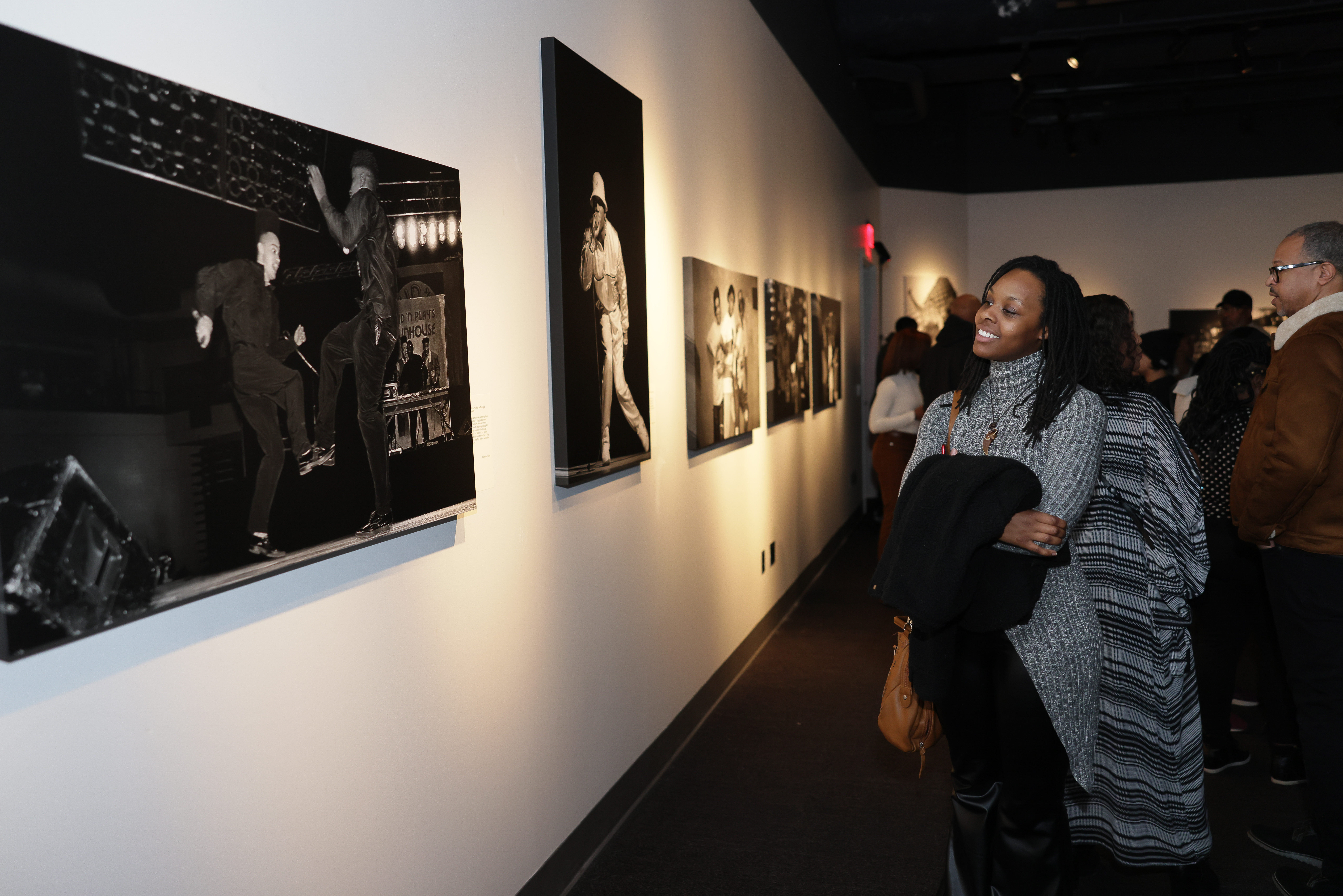 Visitors observe photo exhibit on the gallery walls.