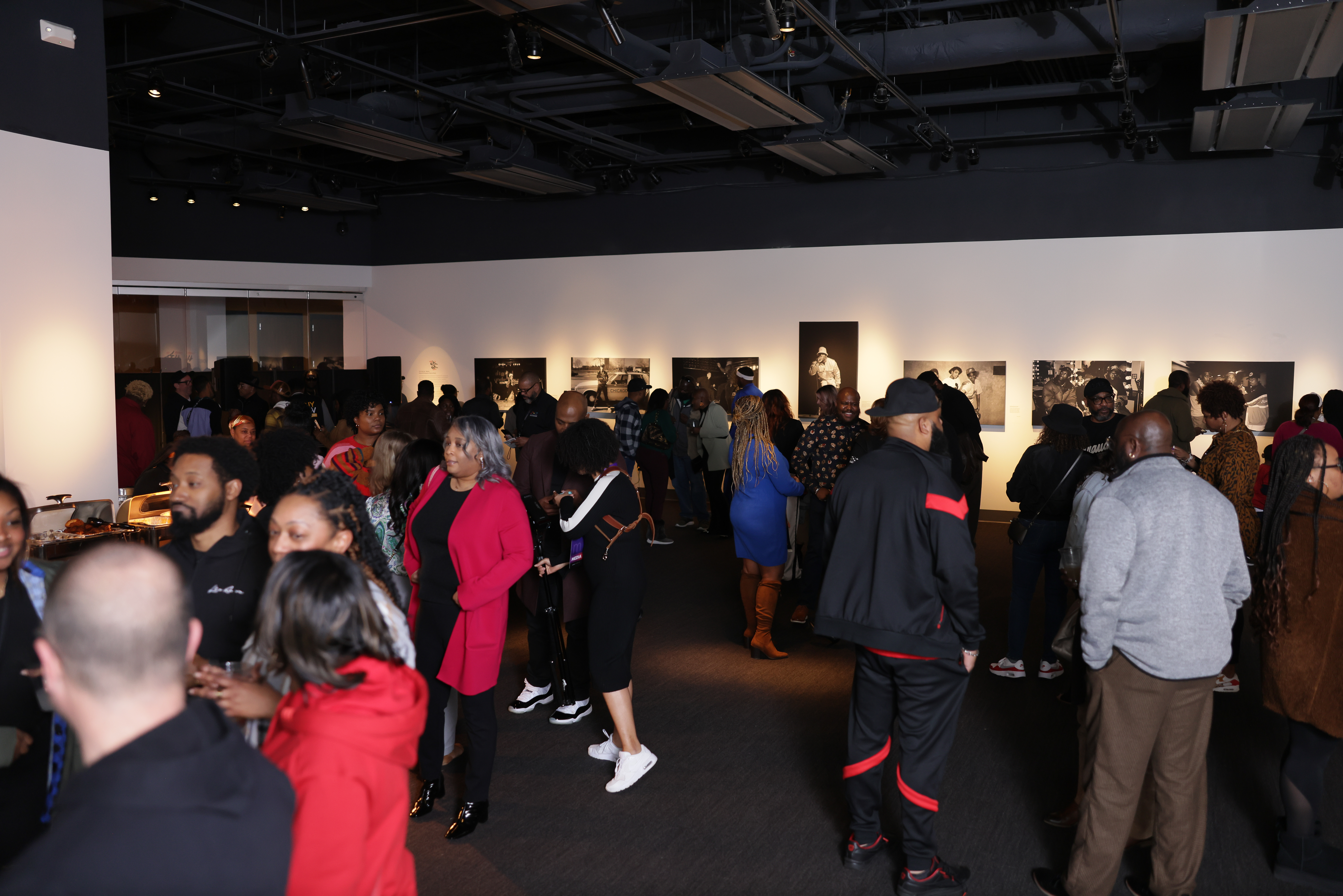 Visitors observe photo exhibit on the gallery walls.