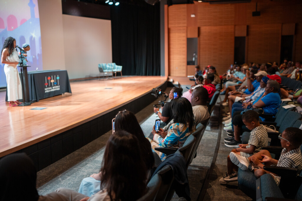 Megan Piphus holding puppet on stage at her event
