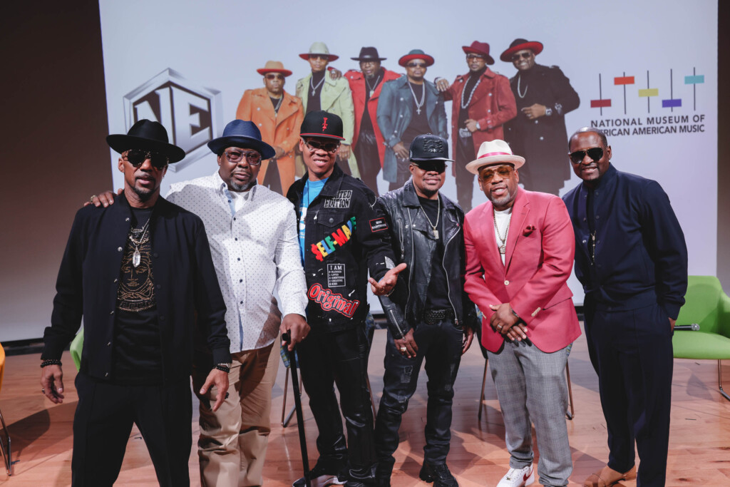 Members of New Edition on stage posing for camera