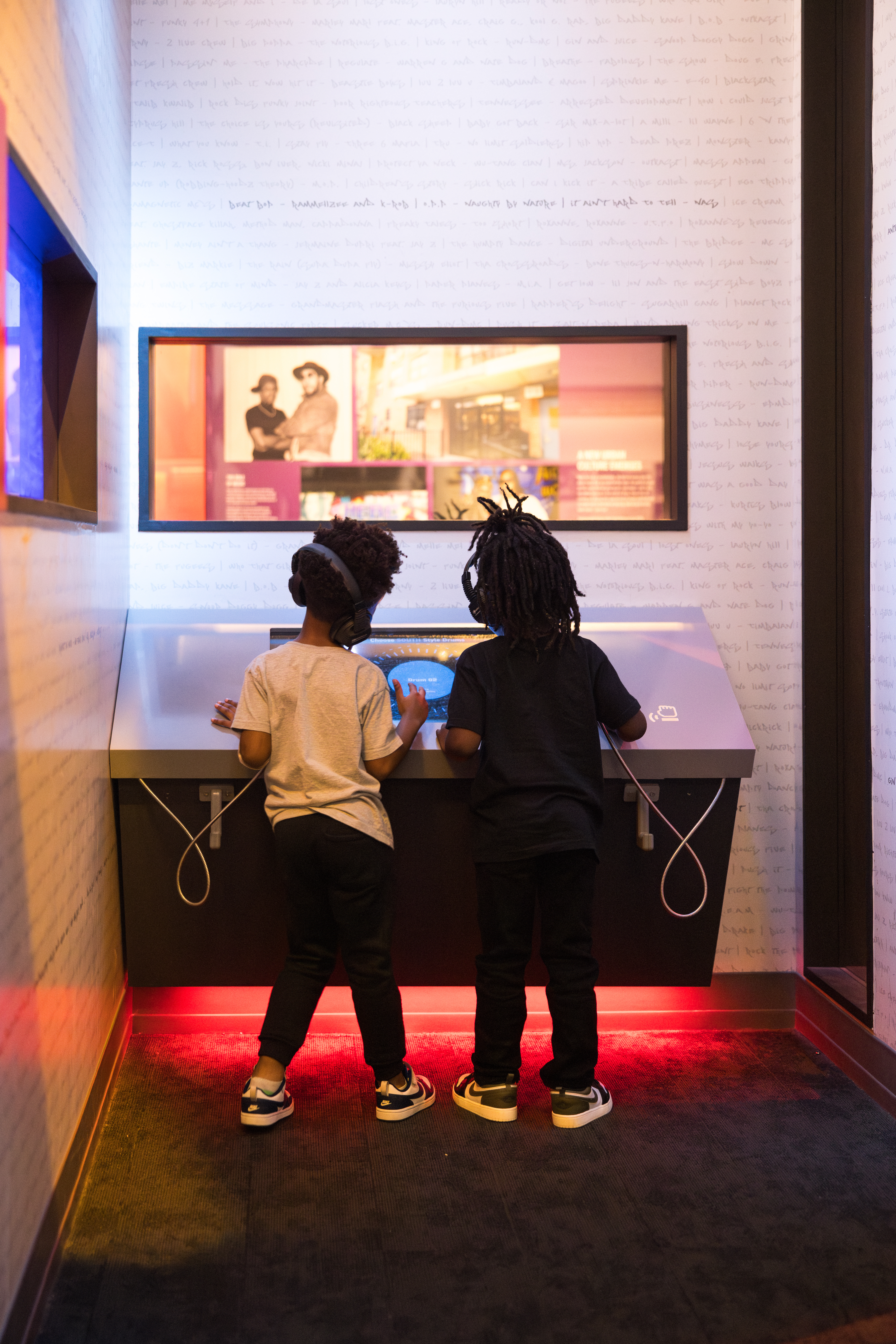 two children pointing at panel in gallery