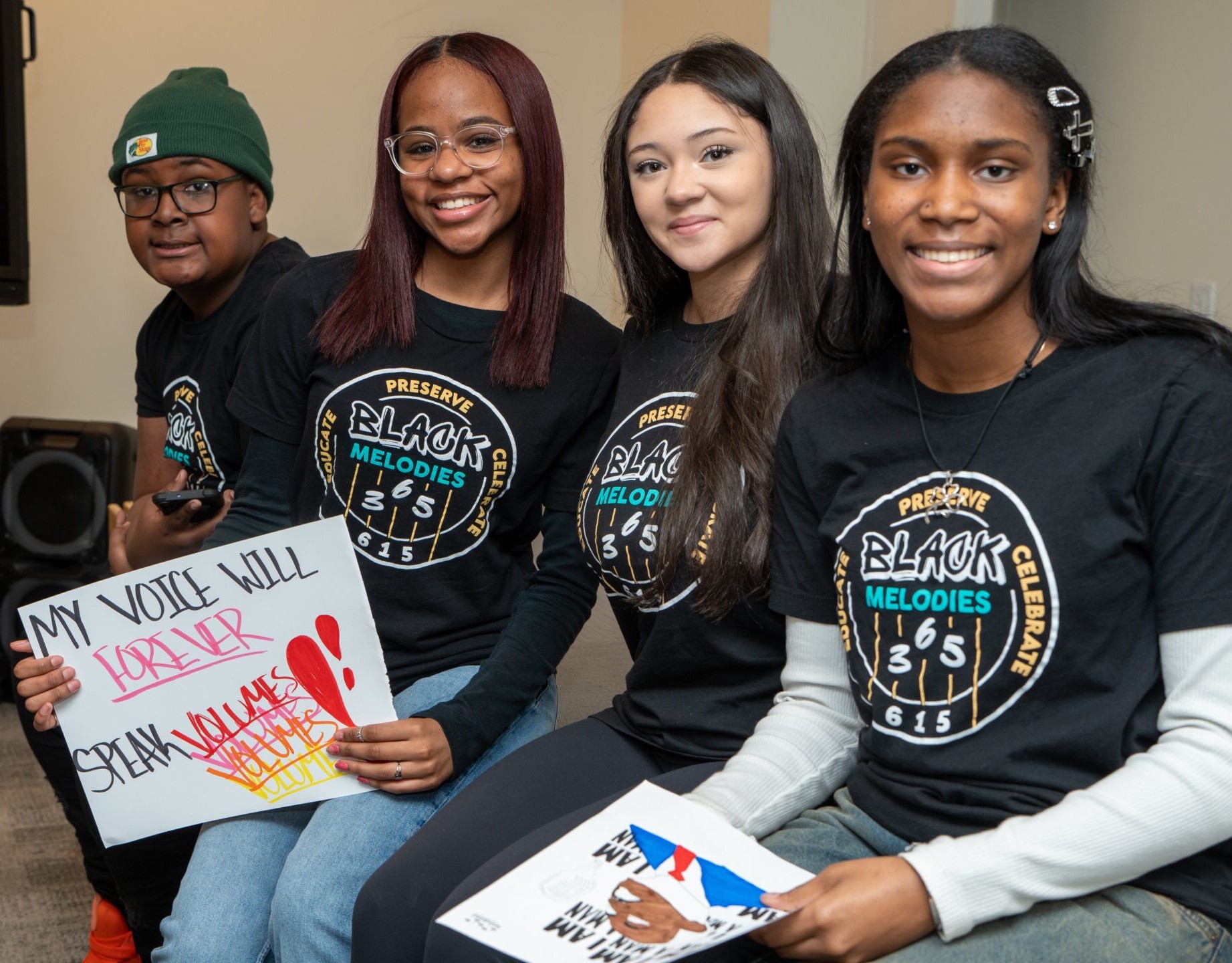 4 young students from Interludes program smiling for camera